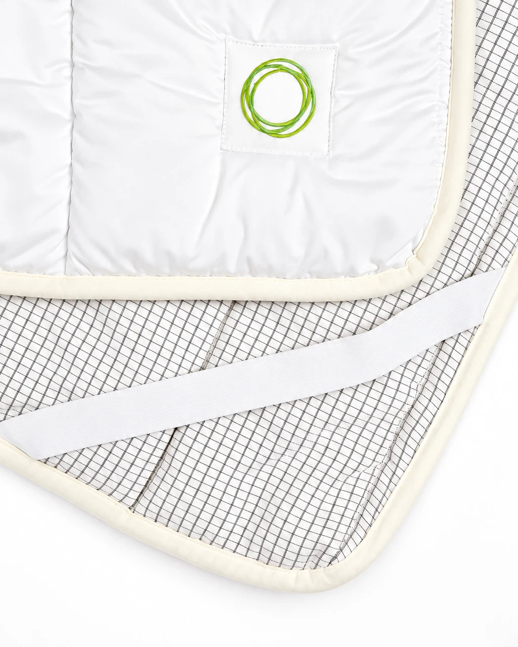 Nahaufnahme der ifibr Schlafauflage mit Fibranium-Logo-Patch und Grid-Textilstruktur
