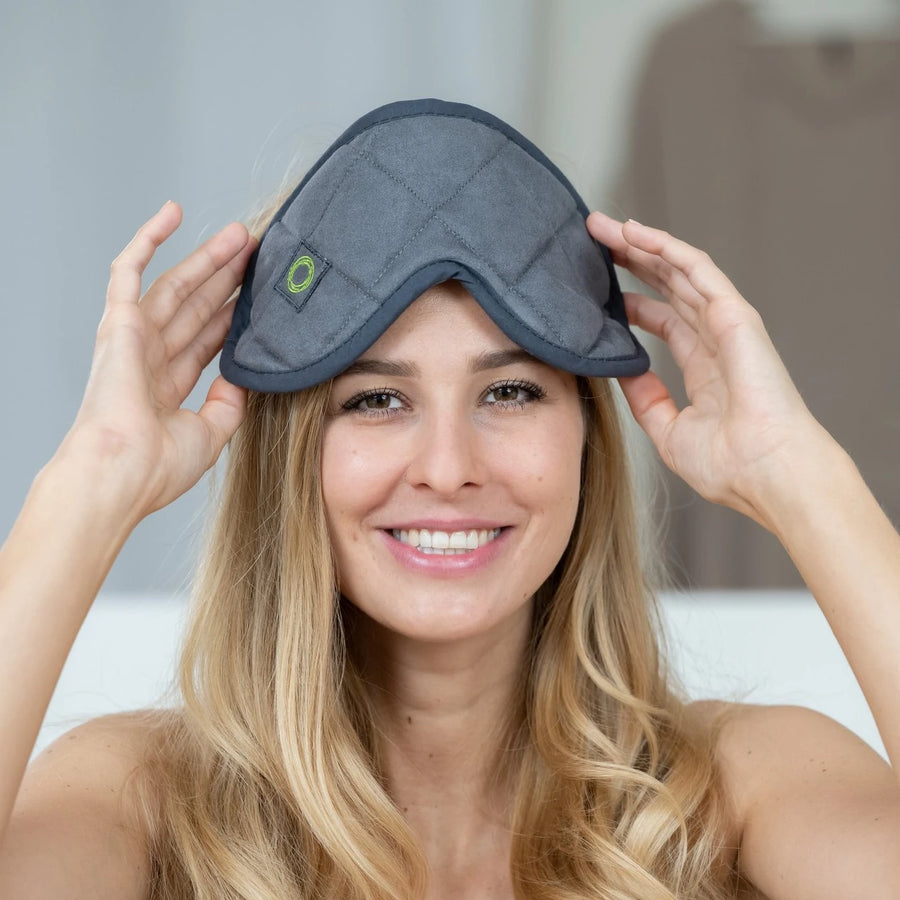 Frau setzt sich die graue ifibr EyeMask mit grünem Logo auf